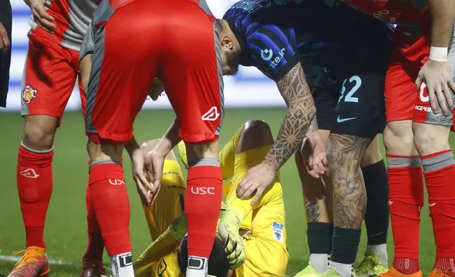 Cremonese's goalkeeper Emil Audero lies on the pitch after fans throw a flair towards him during the Serie A soccer match between Cremonese and Inter in Cremona, Italy, Sunday, Feb. 2026. (Alberto Mariani/LaPresse via AP)