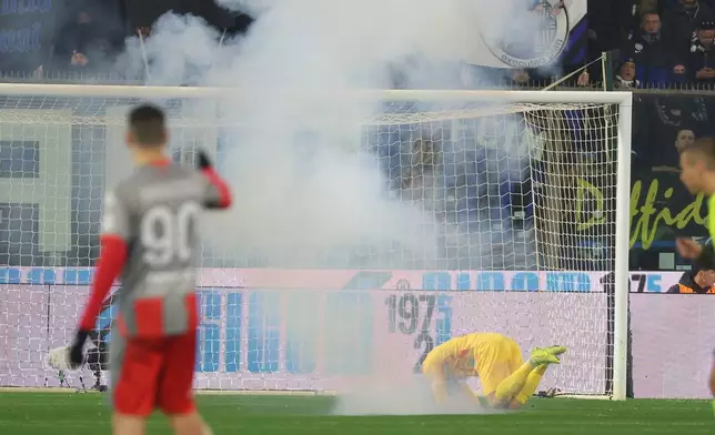 Fans throw a flair towards Cremonese's goalkeeper Emil Audero during the Serie A soccer match between Cremonese and Inter in Cremona, Italy, Sunday, Feb. 2026. (Alberto Mariani/LaPresse via AP)