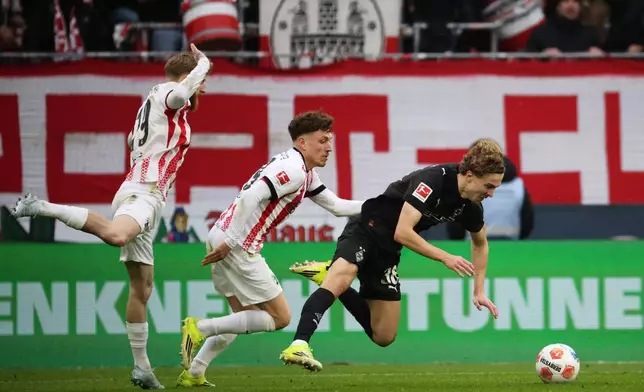 Freiburg's Jan-Niklas Beste, left, and Philipp Treu challenge Mönchengladbach's Hugo Bolin during the Bundesliga soccer match between SC Freiburg and Borussia Mönchengladbach in Freiburg, Germany, Sunday Feb. 22, 2026. (Philipp von Ditfurth/dpa via AP)