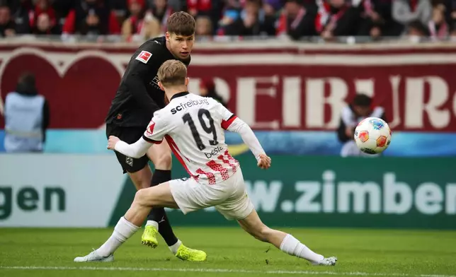 Mönchengladbach's Lukas Ullrich and Freiburg's Jan-Niklas Beste, front, in action during the Bundesliga soccer match between SC Freiburg and Borussia Mönchengladbach in Freiburg, Germany, Sunday Feb. 22, 2026. (Philipp von Ditfurth/dpa via AP)