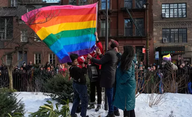 New York politicians and activists raise a rainbow flag on a pole in Christopher Park across the street from the Stonewall Inn, Thursday, Feb. 12, 2026, in New York, a few days after it was removed by the National Park Service to comply with guidance from the Trump administration. (AP Photo/Yuki Iwamura)