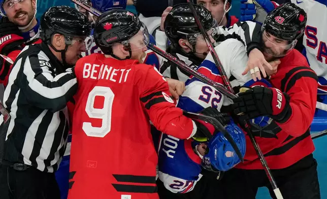 Referees try to break up a fight between Canada's Sam Bennett (9), United States' Charlie McAvoy (25) and Canada's Tom Wilson (43) during the second period of the men's ice hockey gold medal game at the 2026 Winter Olympics, in Milan, Italy, Sunday, Feb. 22, 2026. (AP Photo/Luca Bruno)