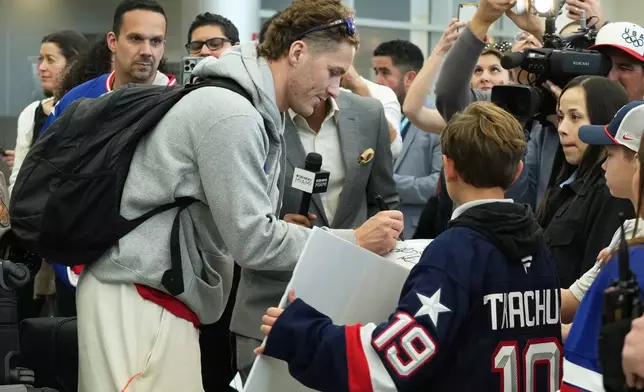 United States' hockey player Matthew Tkachuk signs autographs after arriving at Miami International Airport from the Milan Cortina Olympics, Monday, Feb. 23, 2026, in Miami. (AP Photo/Marta Lavandier)