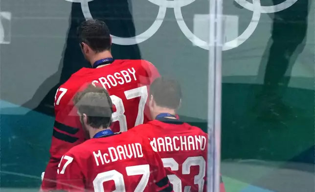 Canada's Sidney Crosby (87), Connor McDavid (97) and Brad Marchand (63) leave the ice following Canada's overtime loss to the United States in the men's ice hockey gold medal game at the 2026 Winter Olympics in Milan, Italy, Sunday, Feb. 22, 2026. (AP Photo/Carolyn Kaster)