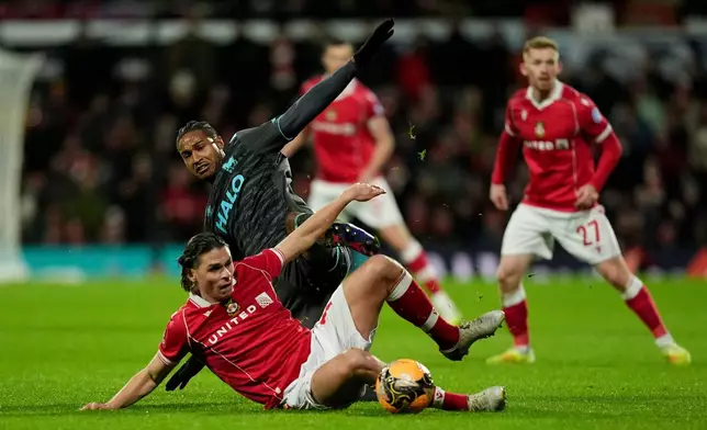 Wrexham's George Dobson, bottom, and Ipswich Town's Jens Cajuste battle for the ball during an English FA Cup fourth round soccer, Friday, Feb. 13, 2026, in Wrexham, Wales. (Martin Rickett/PA via AP)