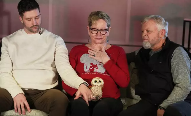 From left, Brent Ganger consoles his mother, Donna, center, and father, Tim Ganger, during an interview in Denver, on Friday, Feb. 27, 2026. (AP Photo/David Zalubowski)