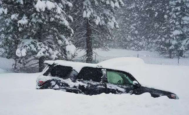 A vehicle is buried in snow during a storm on Tuesday, Feb. 17, 2026 in Truckee Calif. (AP Photos/Brooke Hess-Homeier)