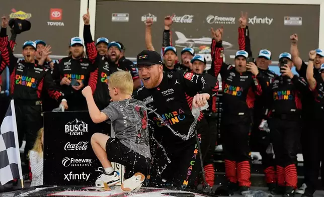 Tyler Reddick, (45) and his son Beau celebrate with the team after winning the NASCAR Daytona 500 auto race at Daytona International Speedway, Sunday, Feb. 15, 2026, in Daytona Beach, Fla. (AP Photo/Mike Stewart)