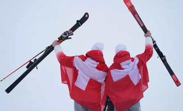 Silver medalist Switzerland's Marco Odermatt, left, and bronze medalist Switzerland's Loic Meillard show their medals for an alpine ski, men's giant slalom race, at the 2026 Winter Olympics, in Bormio, Italy, Saturday, Feb. 14, 2026. (AP Photo/Rebecca Blackwell)