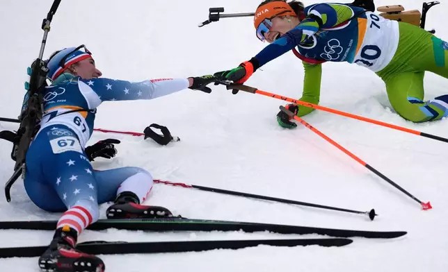Lucinda Anderson, of the United States, left, reaches out to Lena Repinc, of Slovenia, after the women's 7.5-kilometer sprint biathlon race at the 2026 Winter Olympics in Anterselva, Italy, Saturday, Feb. 14, 2026. (AP Photo/Mosa'ab Elshamy)