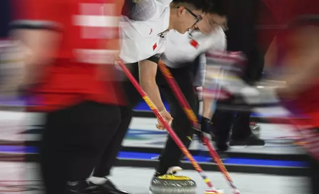 China's Xu Xiaoming and Xu Jingtao in action during the men's curling round robin session against Switzerland at the 2026 Winter Olympics, in Cortina d'Ampezzo, Italy, Saturday, Feb.14, 2026. (AP Photo/Fatima Shbair)