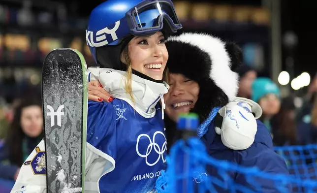 China's Eileen Gu, left, gets a hug from her mother Yan Gu as she competes in the women's freestyle skiing big air qualifications at the 2026 Winter Olympics, in Livigno, Italy, Saturday, Feb. 14, 2026. (AP Photo/Abbie Parr)