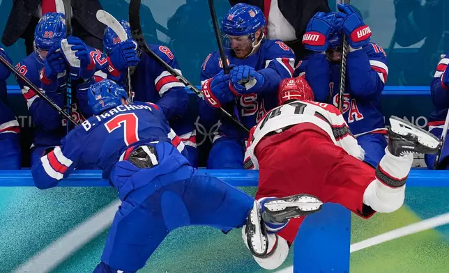 United States' Brady Tkachuk, left, challenges Denmark's Jesper Jensen Aabo during a preliminary round match of men's ice hockey between United States and Denmark at the 2026 Winter Olympics, in Milan, Italy, Saturday, Feb. 14, 2026. (AP Photo/Petr David Josek)