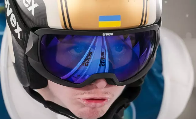 Yevhen Marusiak, of Ukraine, goes down the ramp during his trial jump of the ski jumping men's large hill individual at the 2026 Winter Olympics, in Predazzo, Italy, Saturday, Feb. 14, 2026. (AP Photo/Evgeniy Maloletka)