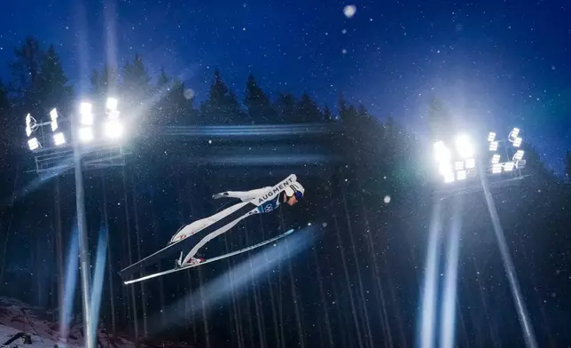 Song Qiwu, of China, soars through the air during the ski jumping men's large hill individual at the 2026 Winter Olympics, in Predazzo, Italy, Saturday, Feb. 14, 2026. (AP Photo/Kirsty Wigglesworth)