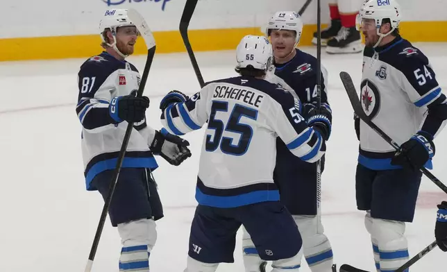 Winnipeg Jets center Mark Scheifele (55) celebrates after scoring the game winning goal during the third period of an NHL hockey game against the Florida Panthers, Saturday, Jan. 31, 2026, in Sunrise, Fla. (AP Photo/Marta Lavandier)