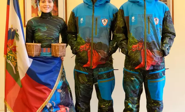 From left, Livia Audain, Haiti's Ambassador to Italy Gandy Thomas, and Megan Thomas pose at the Haitian Embassy in Rome, Saturday, Jan. 31, 2026, with the official uniform for the Haitian national team participating in the 2026 Winter Olympics. (AP Photo/Gregorio Borgia)