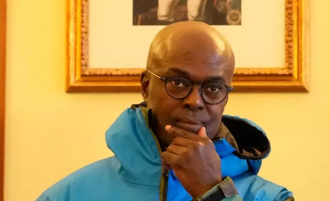 Haiti's Ambassador to Italy, Gandy Thomas, poses at the Haitian Embassy in Rome, Saturday, Jan. 31, 2026, with the official uniform for the Haitian national team participating in the 2026 Winter Olympics. (AP Photo/Gregorio Borgia)