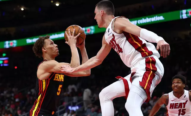 Atlanta Hawks guard Dyson Daniels (5) shoots against Miami Heat guard Tyler Herro, right, during the first half of an NBA basketball game, Friday, Feb. 20, 2026, in Atlanta. (AP Photo/Colin Hubbard)