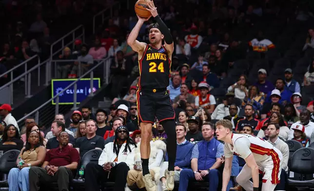 Atlanta Hawks forward Corey Kispert (24) shoots against Miami Heat guard Kasparas Jakucionis, right, during the first half of an NBA basketball game, Friday, Feb. 20, 2026, in Atlanta. (AP Photo/Colin Hubbard)