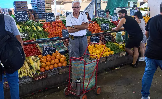 A customer waits to be attended at a greengrocer's stall in Buenos Aires, Argentina, Tuesday, Feb. 10, 2026. (AP Photo/Rodrigo Abd)