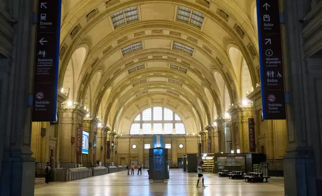 People wait inside the Constitucion railway station that is empty due to a union strike against a proposed labor reform bill in Buenos Aires, Argentina, Thursday, Feb. 19, 2026. (AP Photo/Gustavo Garello)