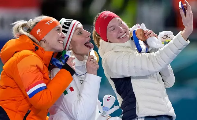 Francesca Lollobrigida of Italy, center and gold medal, Merel Conijn of the Netherlands, left and silver medal, and Ragne Wiklund of Norway, right and bronze medal, celebrate on the podium after the women's 5,000 meters speedskating race at the 2026 Winter Olympics, in Milan, Italy, Thursday, Feb. 12, 2026. (AP Photo/Ben Curtis)