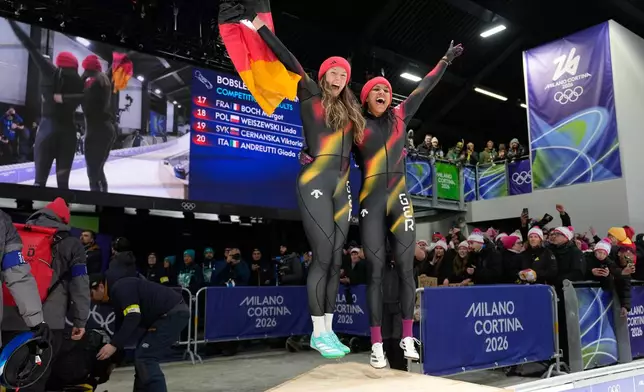 Germany's gold medalists Laura Nolte, left, and Deborah Levi celebrate after the two women bobsled competition at the 2026 Winter Olympics, in Cortina d'Ampezzo, Italy, Saturday, Feb. 21, 2026. (AP Photo/Alessandra Tarantino)
