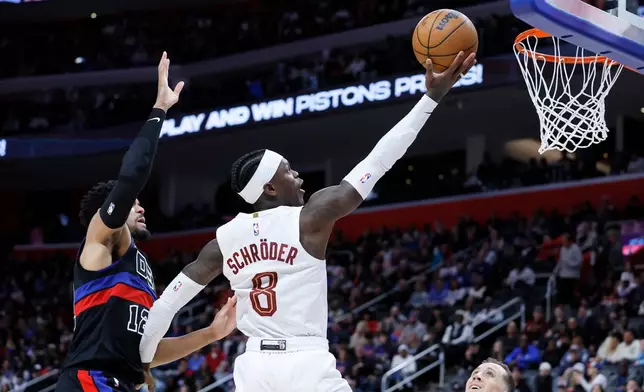 Cleveland Cavaliers guard Dennis Schroder (8) goes to the basket past Detroit Pistons forward Tobias Harris (12) during the second half of an NBA basketball game Friday, Feb. 27, 2026, in Detroit. (AP Photo/Duane Burleson)
