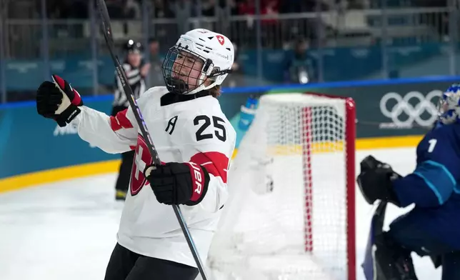 Switzerland's Alina Muller (25) celebrates after scoring against Finland goalkeeper Sanni Ahola (1) during the second period of a women's ice hockey quarterfinal match at the 2026 Winter Olympics, in Milan, Italy, Saturday, Feb. 14, 2026. (AP Photo/Carolyn Kaster)