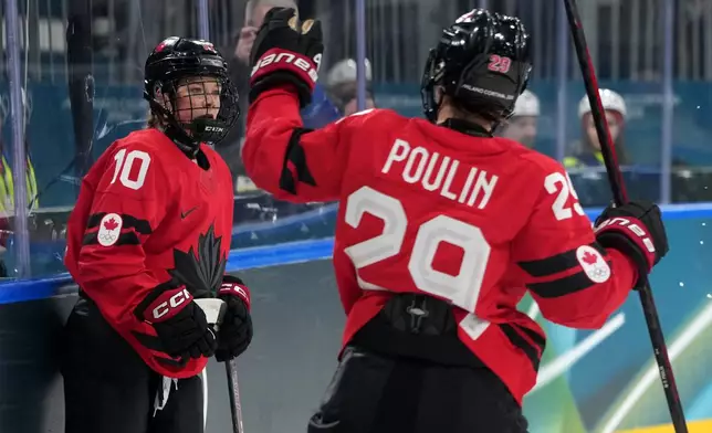 Canada's Sarah Fillier (10) is congratulated by Marie-Philip Poulin (29) after Fuller scored a goal against Germany during the second period of a women's ice hockey quarterfinal match at the 2026 Winter Olympics, in Milan, Italy, Saturday, Feb. 14, 2026. (AP Photo/Carolyn Kaster)