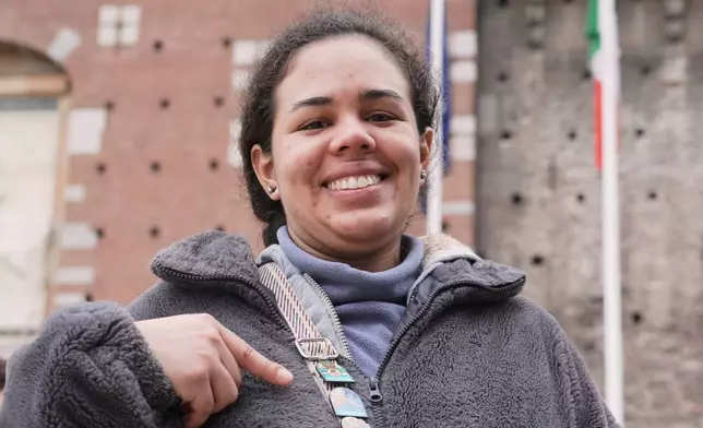 Isabella Botero, a Masters student studying in Milan, displays the YesMilano pins featuring city neighborhoods and landmarks that she has collected in recent days, at the 2026 Winter Olympics, in Milan, Italy, Wednesday, Feb. 11, 2026. (AP Photo/Mustakim Hasnath)
