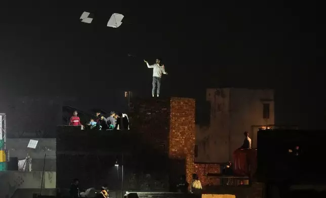 People gather on their decorated rooftops to celebrate the Basant kite flying festival in Lahore, Pakistan, late Friday, Feb. 6, 2026. (AP Photo/K.M. Chaudary)
