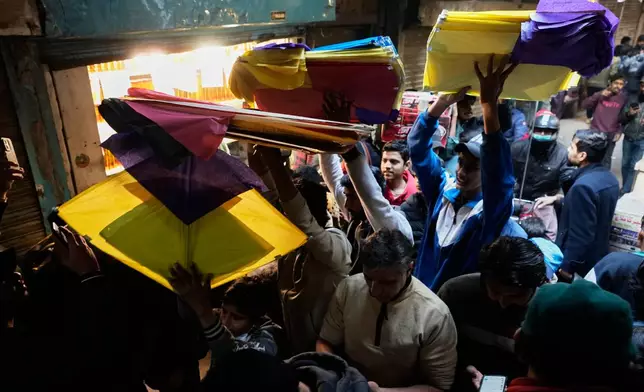 Pakistani hold kites on their way to celebrate the upcoming three-day kite flying festival Basant, in Lahore, Pakistan, Sunday, Feb. 1, 2026. (AP Photo/K.M. Chaudary)
