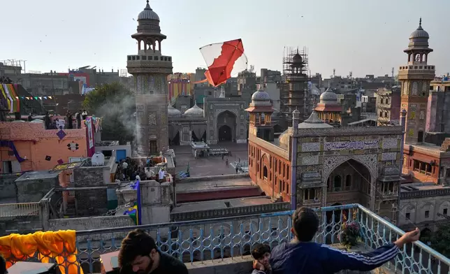 A man flies a kite from the rooftop of his house to celebrate three-day kite flying festival 'Basant', in Lahore, Pakistan, Friday, Feb. 6, 2026. (AP Photo/K.M. Chaudary)