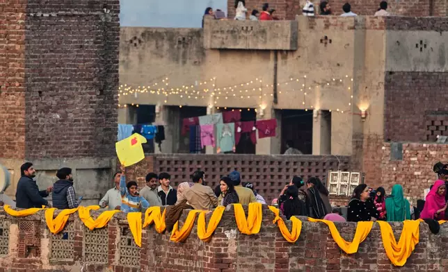 Families gather on the rooftops of their houses to celebrate the three-day kite flying festival 'Basant', in Lahore, Pakistan, Friday, Feb. 6, 2026. (AP Photo/K.M. Chaudary)