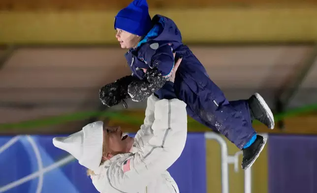 United States' bronze medalist Kaillie Armbruster Humphries lifts her son Aulden after the women's monobob competition at the 2026 Winter Olympics, in Cortina d'Ampezzo, Italy, Monday, Feb. 16, 2026. (AP Photo/Aijaz Rahi)