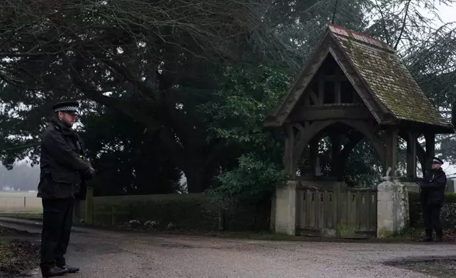 Police officers guard the entrance to the Sandringham Royal Estate in Sandringham, England, Thursday, Feb. 19, 2026 after Andrew Mountbatten-Windsor was arrested by British police on suspicion of misconduct in public office. (AP Photo/Alastair Grant)