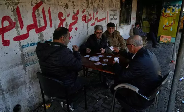 Palestinian public transportation drivers play cards while they wait for passengers at the main bus station, in the West Bank city of Tulkarem Sunday, Jan. 18, 2026. (AP Photo/Nasser Nasser)