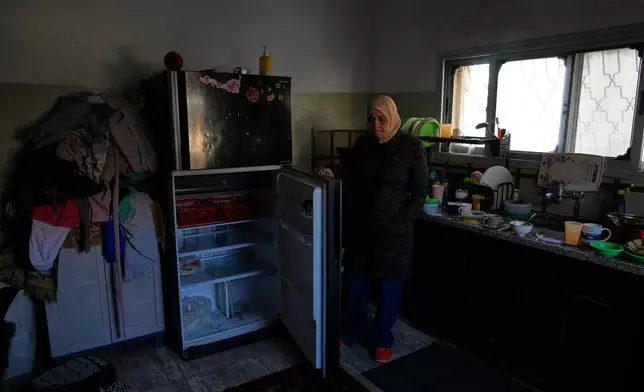 Palestinian laborer Shuhrat Barghouthi shows her empty fridge, saying that she struggles to buy food after Israel revoked work permits for Palestinians in the West Bank city of Tulkarem Sunday, Jan. 18, 2026. (AP Photo/Nasser Nasser)