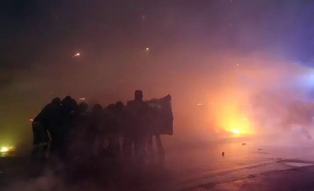 Demonstrators face the police during a protest against the Milan-Cortina 2026 Olympics, in Milan, Italy, Saturday Feb. 7, 2026. (Claudio Furlan/LaPresse via AP)