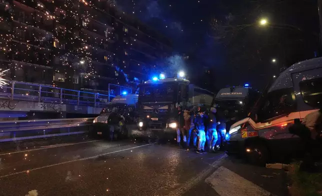 Police officers block the street in from of demonstrators marching against the Milan-Cortina 2026 Olympics, in Milan, Italy, Saturday Feb. 7, 2026. (Claudio Furlan/LaPresse via AP)