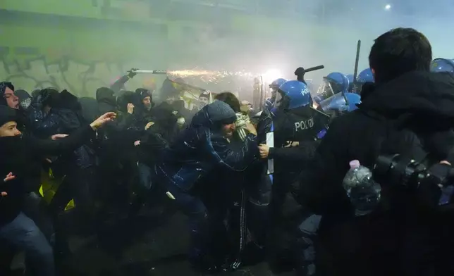 Demonstrators clash with police during a protest against the Milan-Cortina 2026 Olympics, in Milan, Italy, Saturday Feb. 7, 2026. (Claudio Furlan/LaPresse via AP)