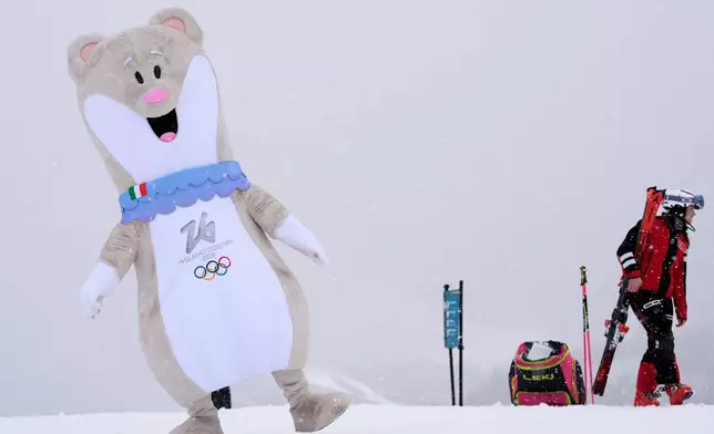 An Olympic mascot dances near the finish line of an alpine ski women's downhill training, at the 2026 Winter Olympics, in Cortina d'Ampezzo, Italy, Saturday, Feb. 7, 2026. (AP Photo/Robert F. Bukaty)