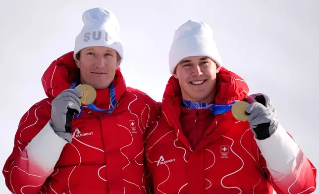 Switzerland's Franjo von Allmen, right, and teammate Switzerland's Tanguy Nef show their gold medals in an alpine ski men's team combined race, at the 2026 Winter Olympics, in Bormio, Italy, Monday, Feb. 9, 2026. (AP Photo/Julia Demaree Nikhinson)