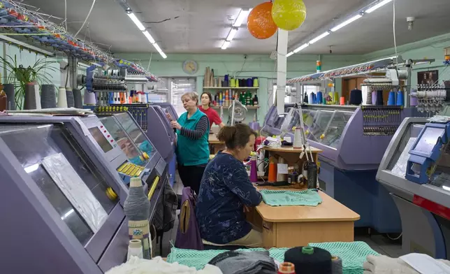 Employees of the Rito Group, a clothing company that produces knitwear, work on a generator during a blackout caused by Russia's regular air attacks on the country's energy system Friday, Jan. 30, 2026, in Kyiv. (AP Photo/Efrem Lukatsky)