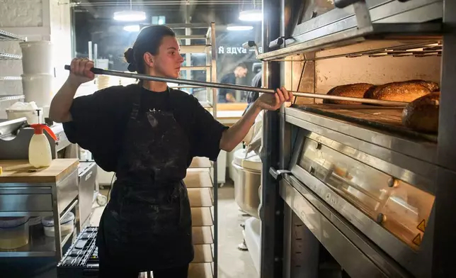 Olha Hrynchuk, 28, owner of a bakery, bakes bread early morning running on a generator during a blackout caused by Russia's regular air attacks on the country's energy system Friday, Jan. 30, 2026 in Kyiv. (AP Photo/Efrem Lukatsky)