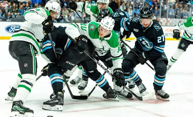 Dallas Stars players fight for the puck against Utah Mammoth players during the first period of an NHL hockey game Saturday, Jan. 31, 2026, in Salt Lake City. (AP Photo/Melissa Majchrzak)
