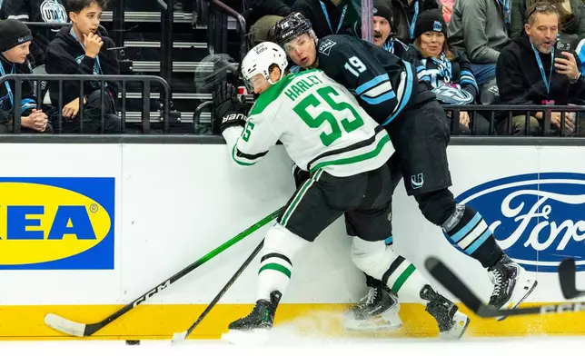 Utah Mammoth left wing Daniil But (19) fights for the puck against Dallas Stars defenseman Thomas Harley (55) during the first period of an NHL hockey game Saturday, Jan. 31, 2026, in Salt Lake City. (AP Photo/Melissa Majchrzak)