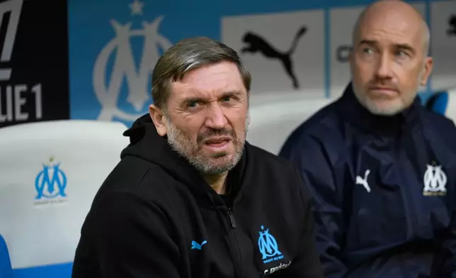 Marseille's interim coach Jacques Abardonado, left, sits on the bench prior to the French League One soccer match between Marseille and Strasbourg in Marseille, France, Saturday, Feb. 14, 2026. (AP Photo/Philippe Magoni)